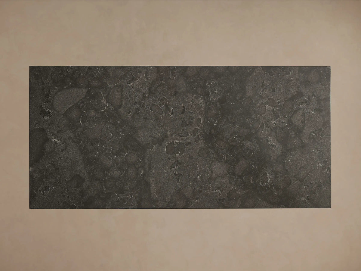 Front view of a dark grey-green mottled stone dining table, featuring a rectangular top and thick trapezoidal base.