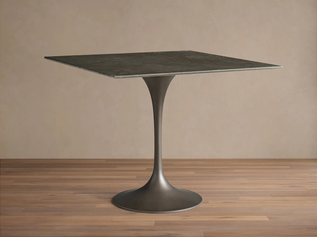 Front view of the dark gray natural stone Saint Germain Square Bistro Table with a flared, dark steel pedestal base.