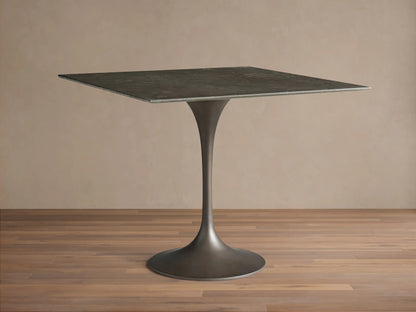 Front view of the dark gray natural stone Saint Germain Square Bistro Table with a flared, dark steel pedestal base.