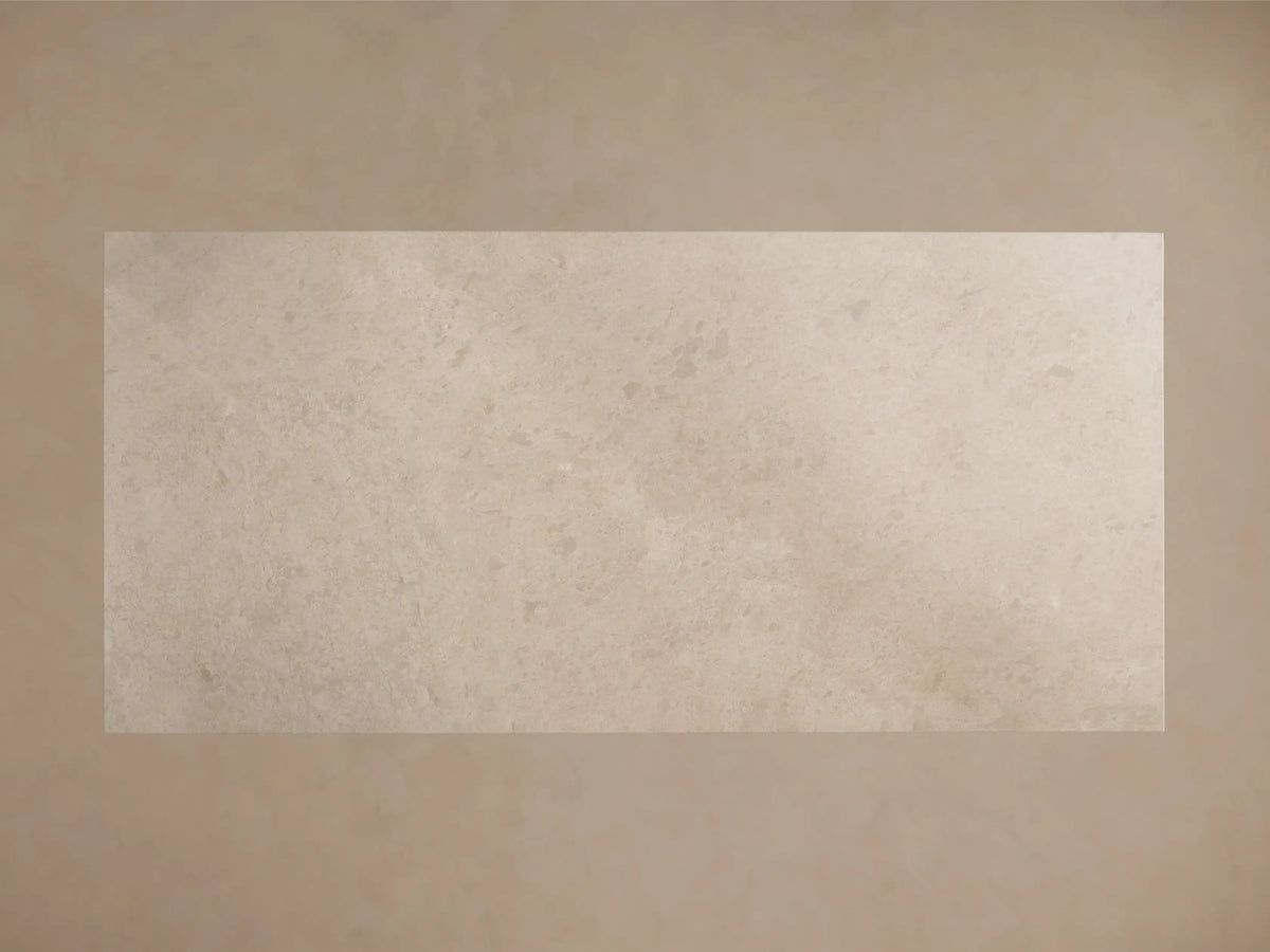 Front view of the light beige rectangular stone dining table with a thick top and a tapered, sculptural pedestal base.