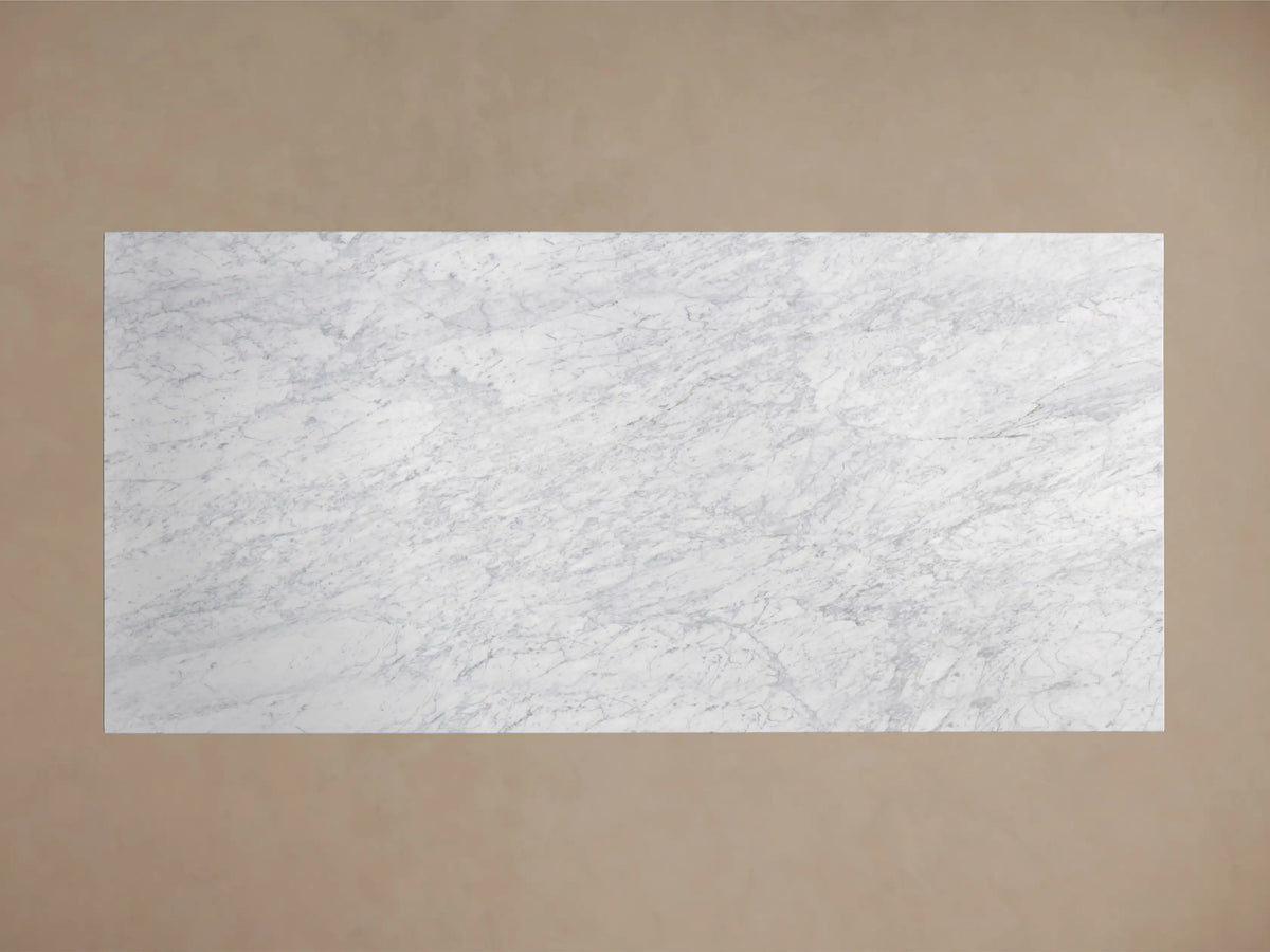 Front view of a white marble table with a rectangular top and a wide trapezoidal pedestal base.