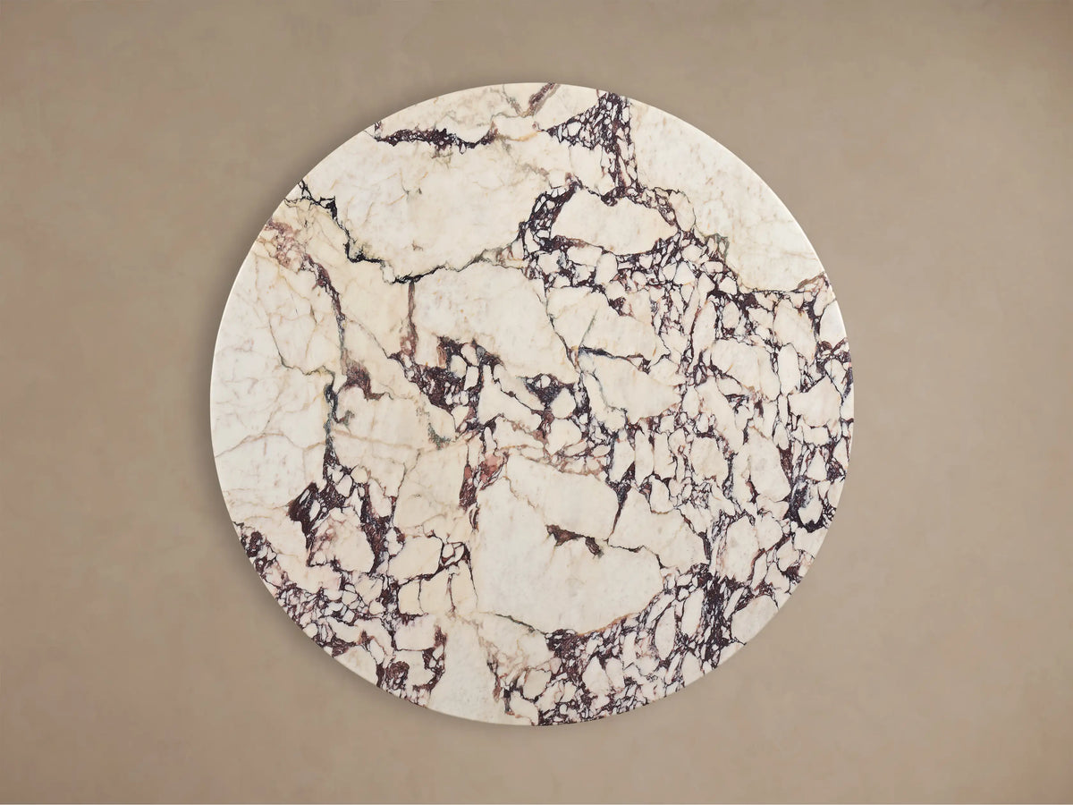 Front view of the Saint Germain Round Stone Dining Table with a white and dark veined stone top and black oak Dauphine Base.