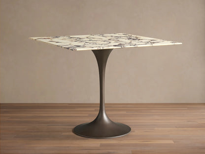 Front view of the Saint Germain Square Bistro Table, with a white marble top with dark veining and a dark steel tulip base.