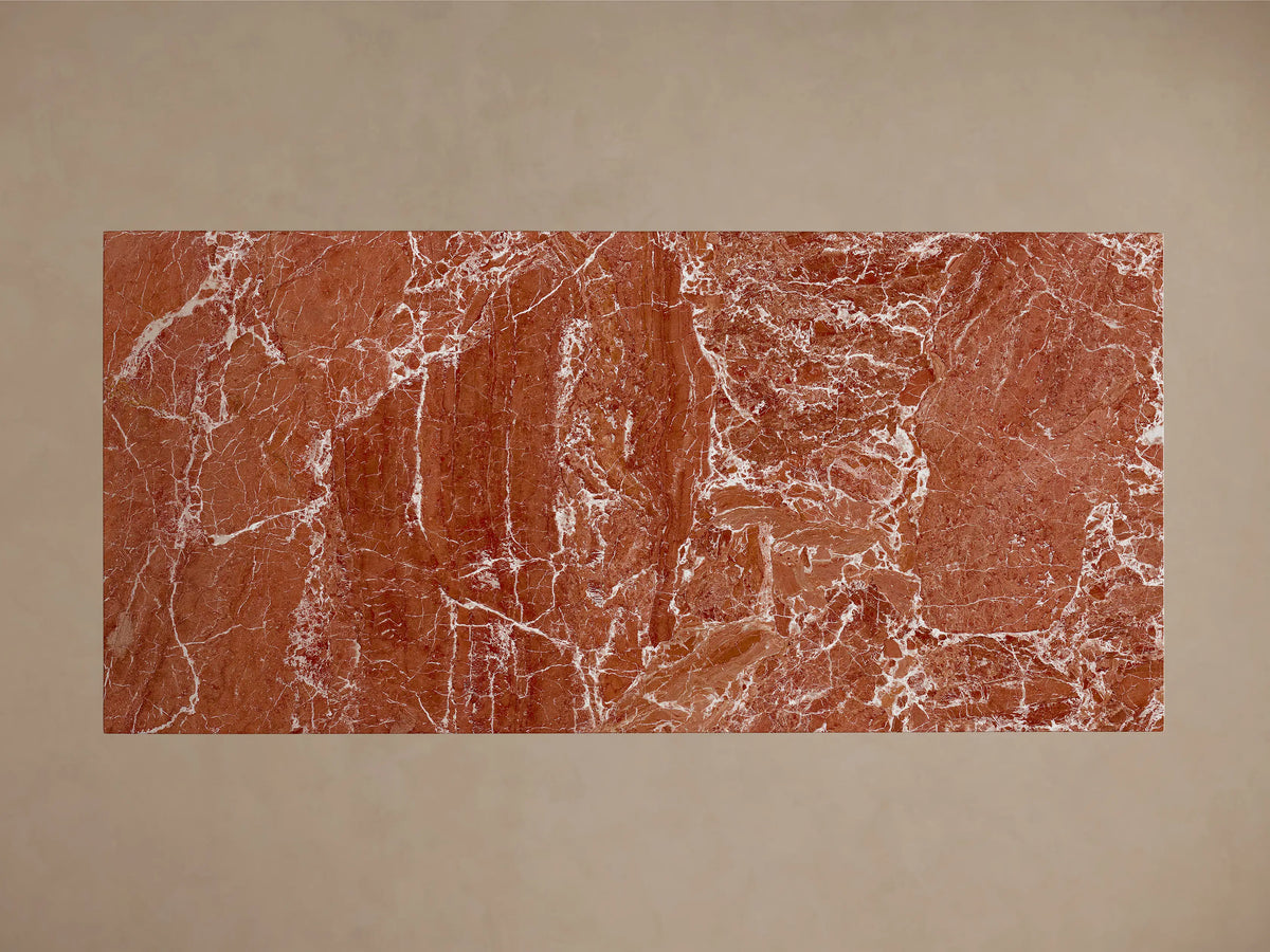 Top-down view of the rectangular Ilaria Dining Table, featuring a reddish-brown natural stone surface with intricate white veining.