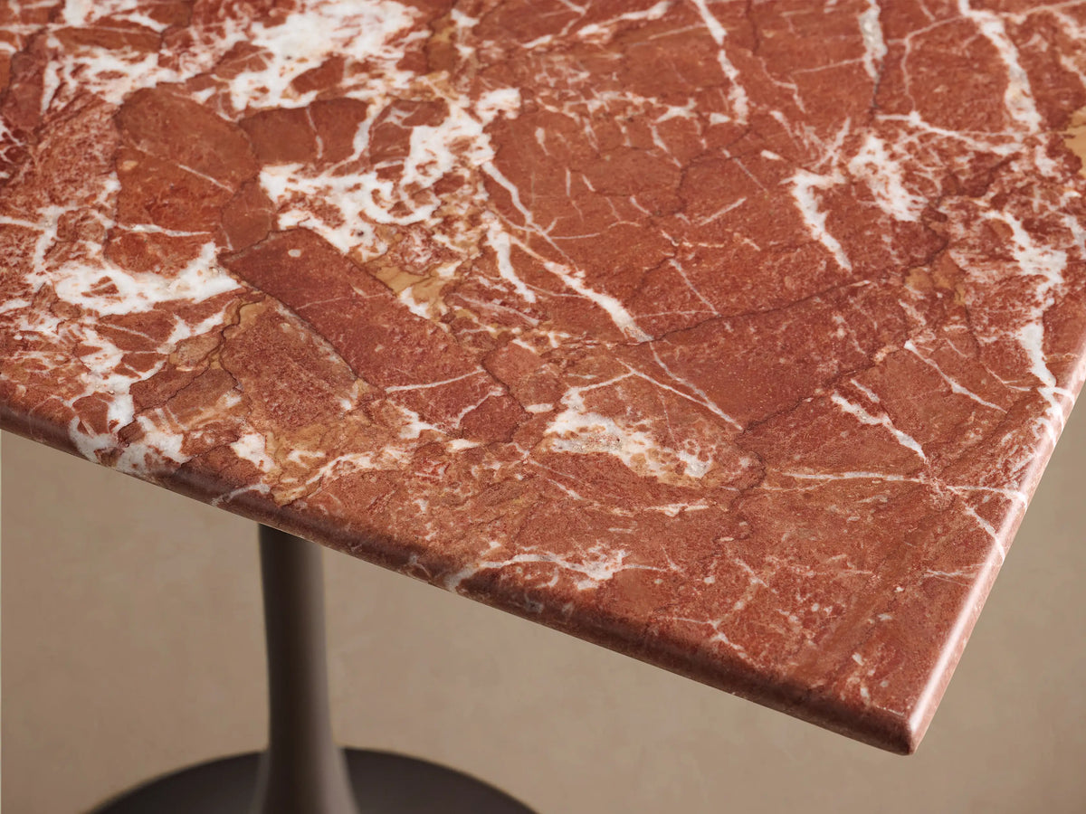 Close-up of the red marble top with white veining on the Saint Germain Square Counter Table, showing its dark steel base.