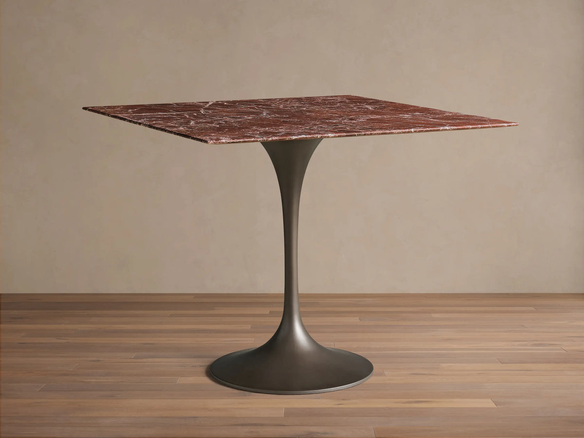 Front view of the Saint Germain Square Bistro Table with a square red marble top and dark steel tulip-shaped pedestal base.
