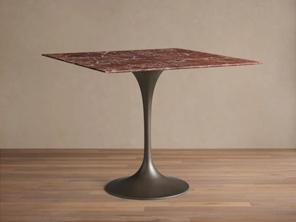 Front view of the Saint Germain Square Bistro Table with a square red marble top and dark steel tulip-shaped pedestal base.