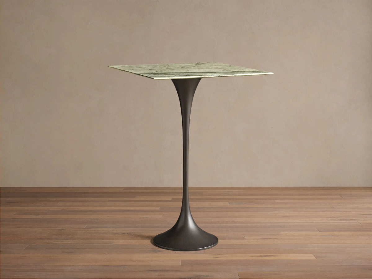Front view of Saint Germain Square Bar Table with a light green marble top featuring dark grey veining, on a black steel flared base.