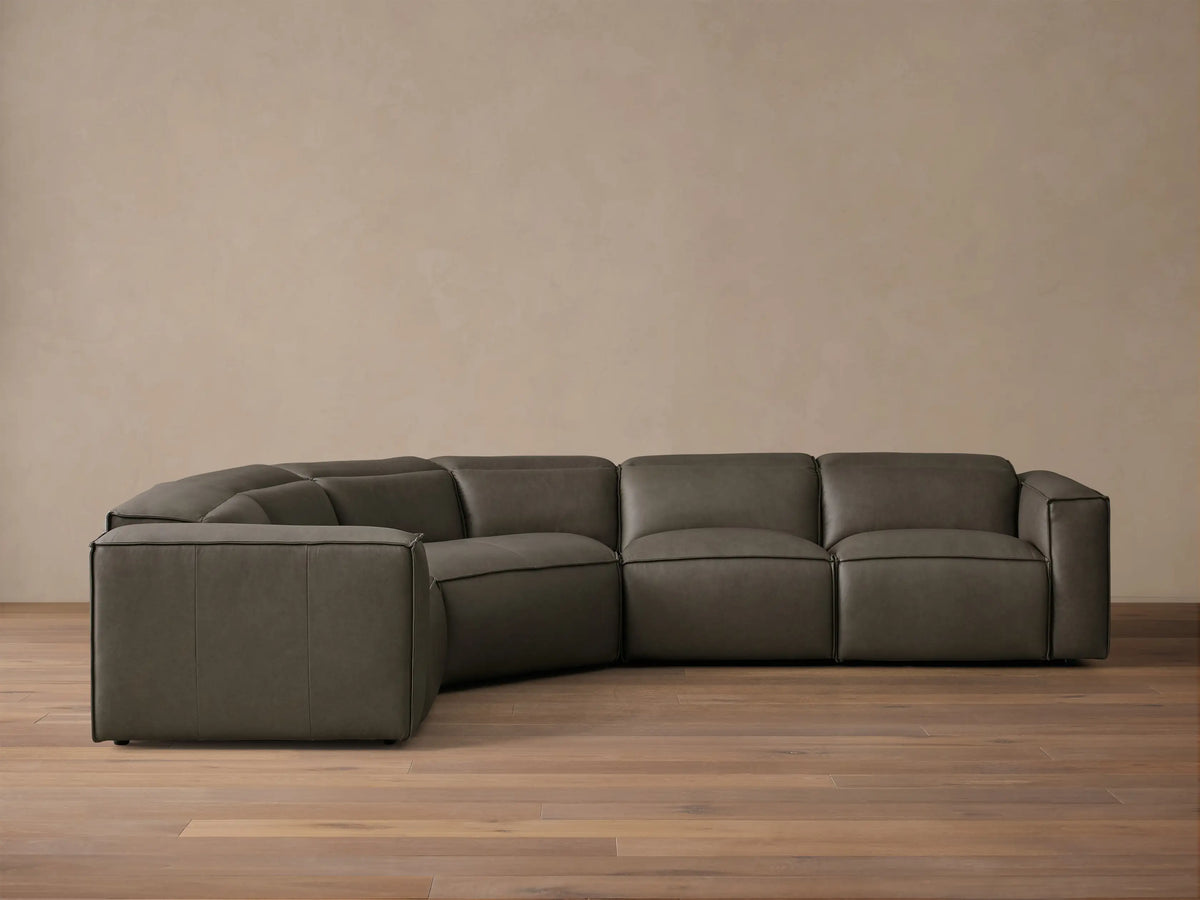 Front view of the dark grey Coburn Motion Leather Four-Piece Corner Wedge Sectional with visible stitching.
