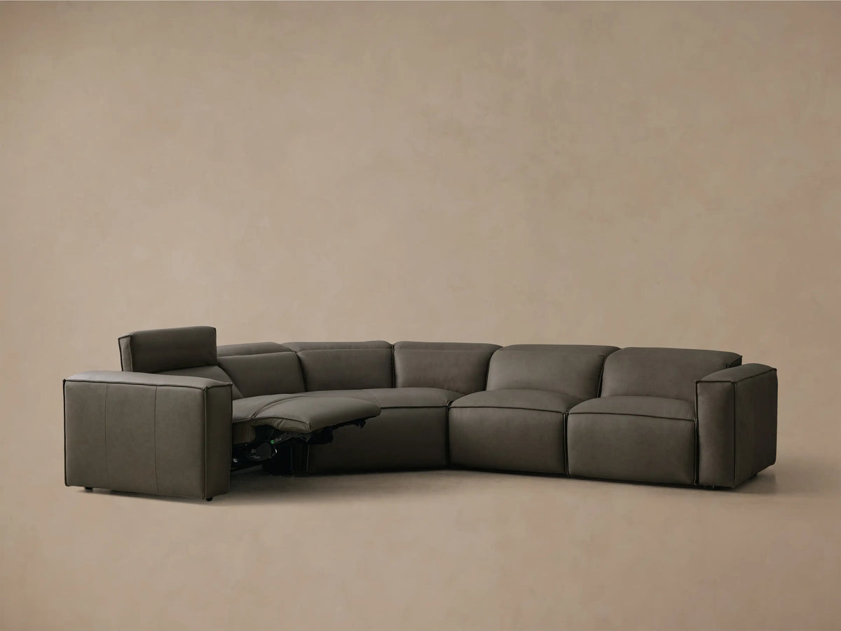 Front view of the charcoal gray Coburn Motion Leather Four-Piece Corner Wedge Sectional with the left arm recliner extended.
