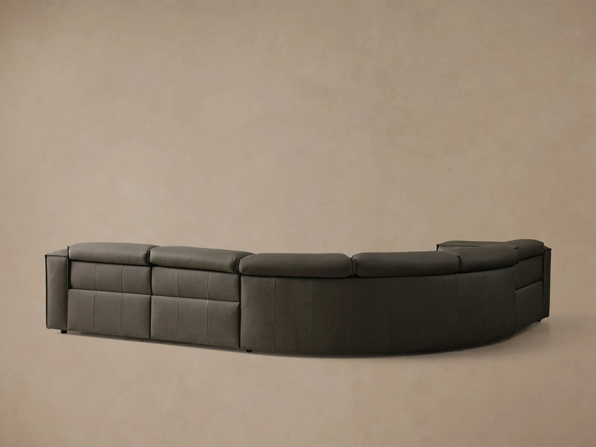 Rear view of the dark gray Coburn Motion Leather Four-Piece Corner Wedge Sectional, showing its curved back with panel stitching.