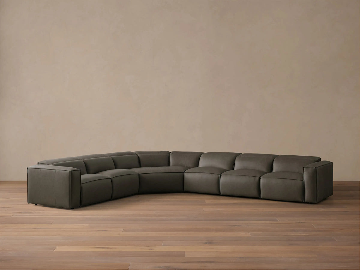 Front view of the dark grey leather Coburn Motion Leather Six-Piece Corner Wedge Sectional with defined stitching.