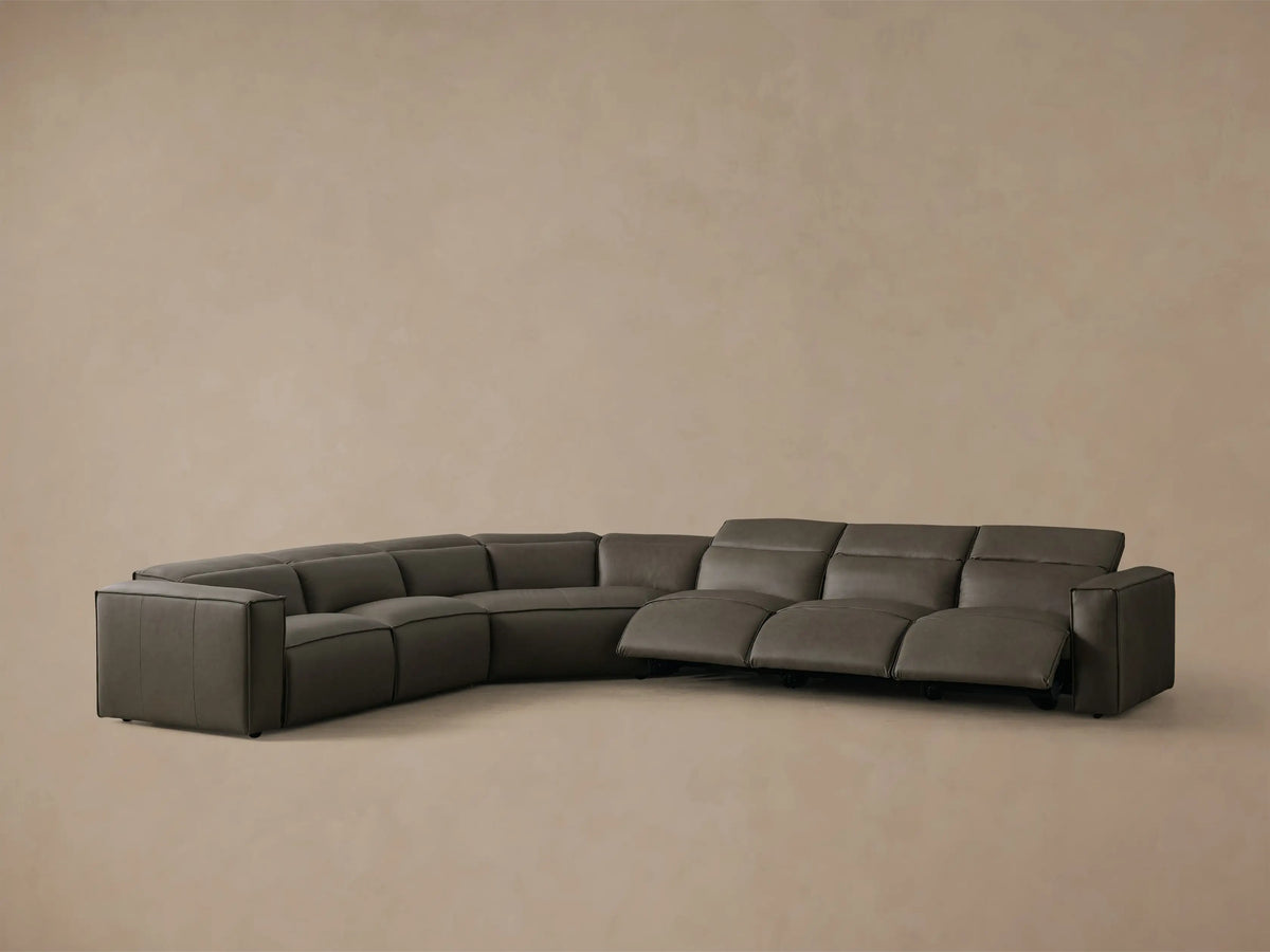Front view of a dark gray leather Coburn Motion Leather Six-Piece Corner Wedge Sectional with the left arm recliner extended.