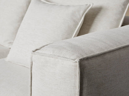 A large, L-shaped white Coburn Five Piece Bumper Sectional sofa with plush back cushions, resting on a warm wood floor.