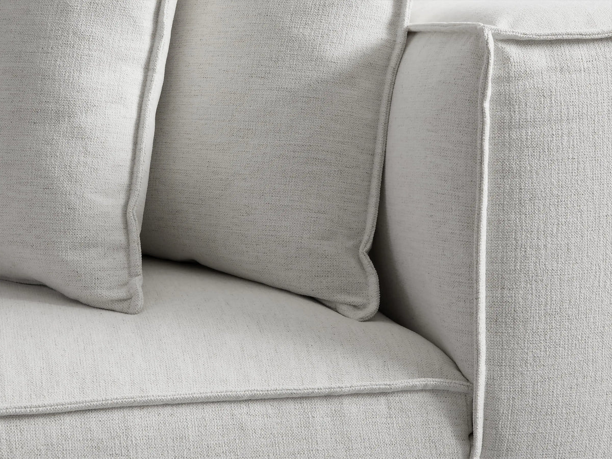 Light grey Coburn Chaise, seen from the rear right angle. It features a modern, blocky design with a plush back cushion.