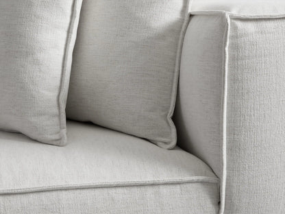 Light grey Coburn Chaise, seen from the rear right angle. It features a modern, blocky design with a plush back cushion.
