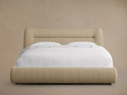 Fawn textured performance fabric Lille Bed with a curved headboard and footboard, dressed in crisp white bedding.