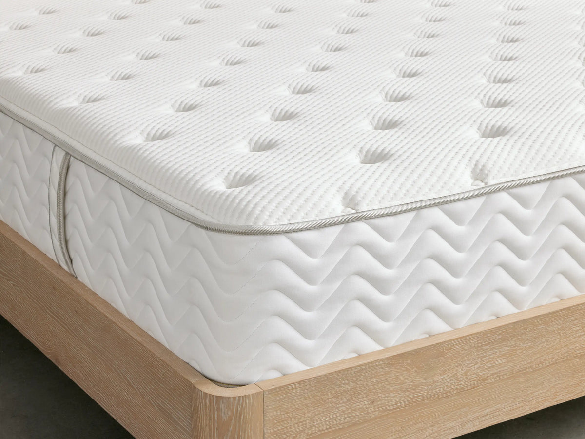 Premium Firm Mattress close-up showing quilted cotton surface with uniform, dimply texture in a soft white color.