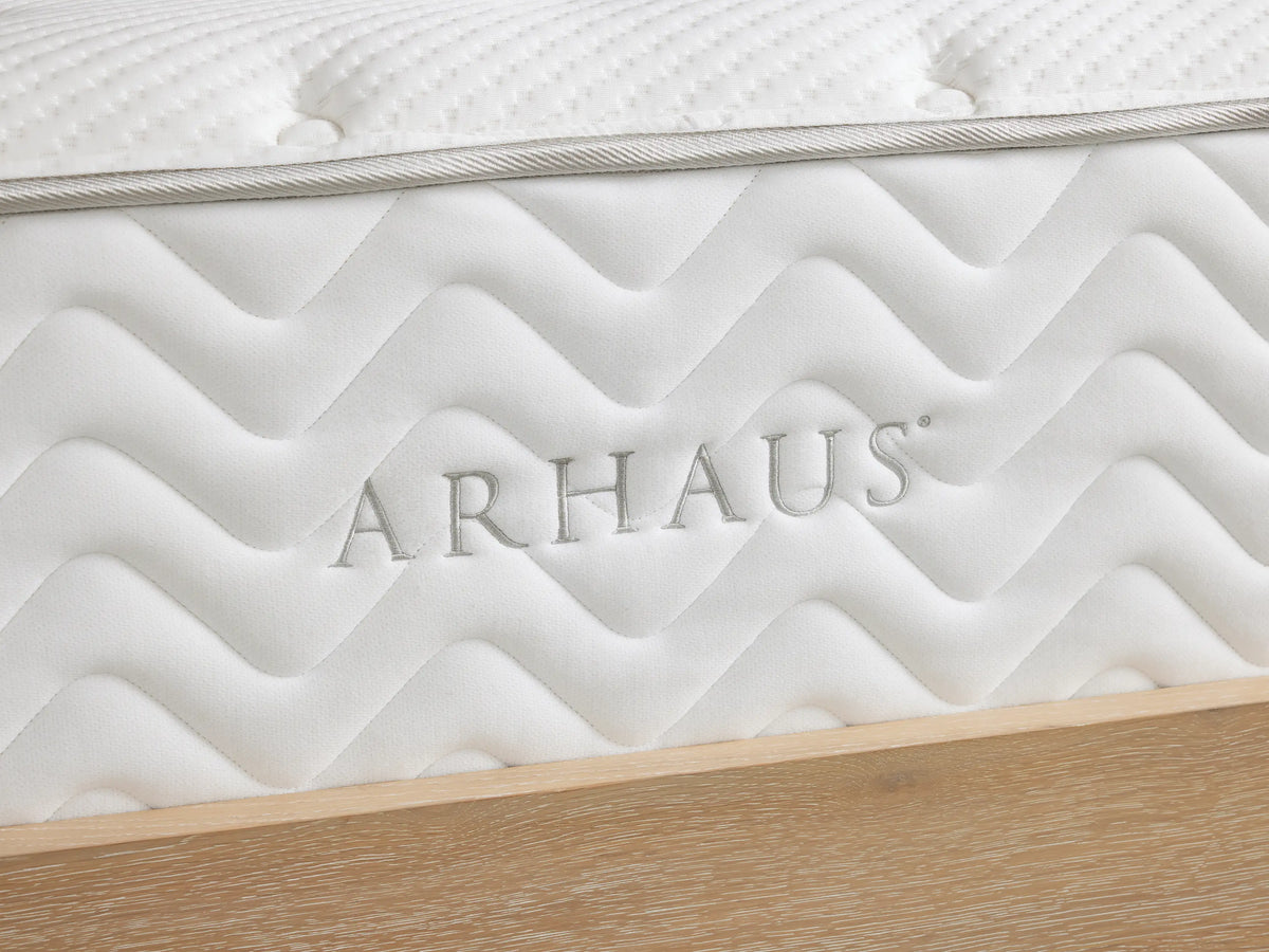 Premium Firm Mattress on a wooden bed frame, featuring a white, quilted cotton cover with tufted texture and zigzag side pattern.