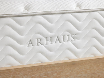 Premium Firm Mattress on a wooden bed frame, featuring a white, quilted cotton cover with tufted texture and zigzag side pattern.