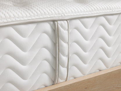 Premium Firm Mattress with white quilted pattern, embossed logo "Zarevium," and beige wooden base visible at the bottom.