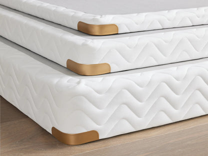 Premium 2" Platform with brass-finished corner guard, white fabric with a zigzag pattern, on a wooden floor.
