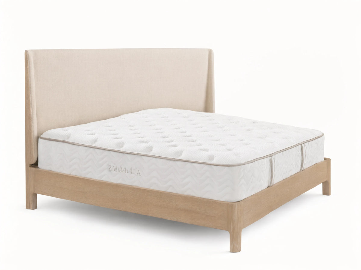 Premium Plush Mattress on a wooden bed frame with a beige headboard. The mattress is quilted white with a subtle geometric pattern.