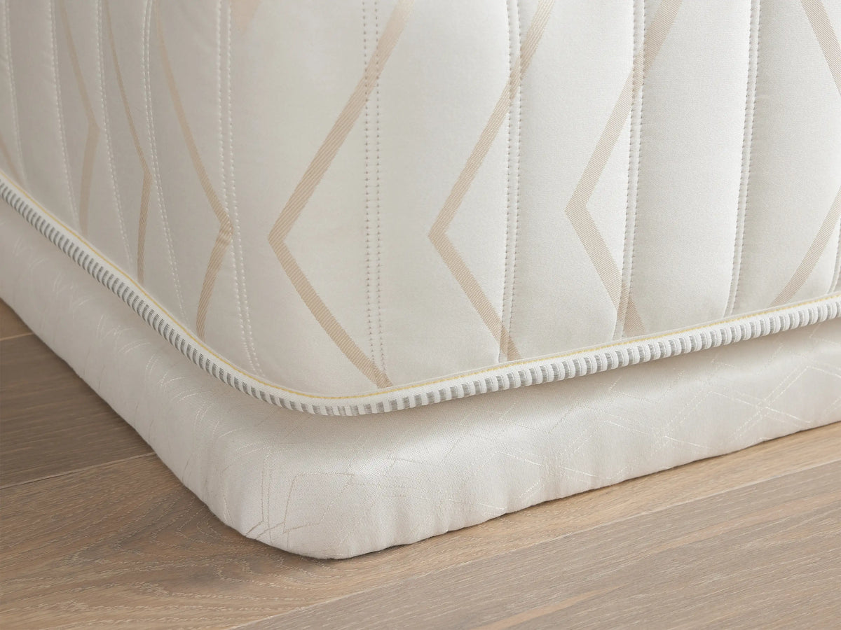 Luxury 2” Platform with a geometric pattern on white fabric, angled view showing the upholstered corner on a wooden floor.