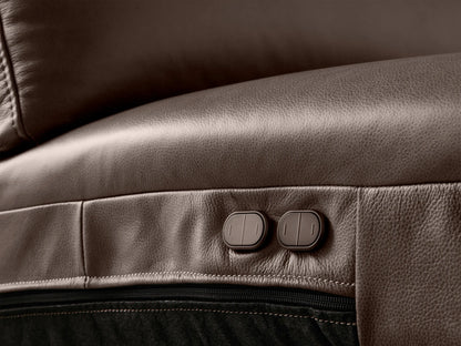 Close-up of a brown Brennan Leather Three-Piece Motion Sofa, extended footrest, smooth texture, detailed stitching.