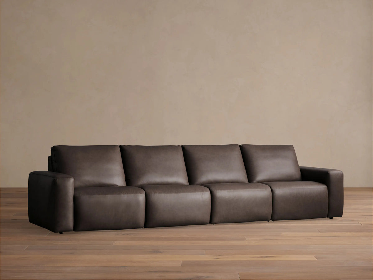 Brennan Four-Piece Motion Sectional in dark brown leather, full front view, on a light wood floor against a neutral wall.