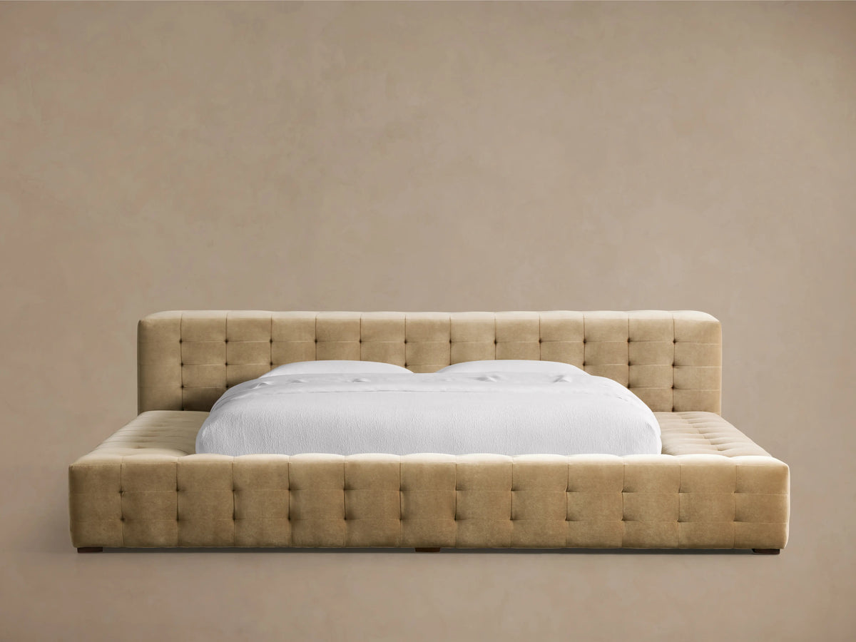 Regent Bed, light tan tufted upholstered headboard & frame, featuring a white mattress with clean white bedding.
