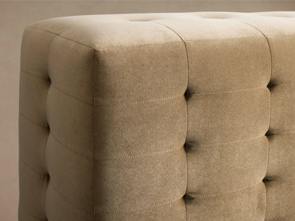 Regent Bed: Tufted beige upholstered bed frame & tall headboard with white mattress, sheets & pillows, viewed from side.