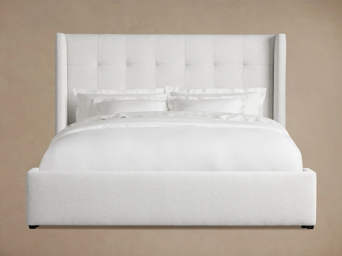 Wyller Box-Tufted Bed, light grey upholstered with tall box-tufted headboard & low footboard, white bedding on wood floor.