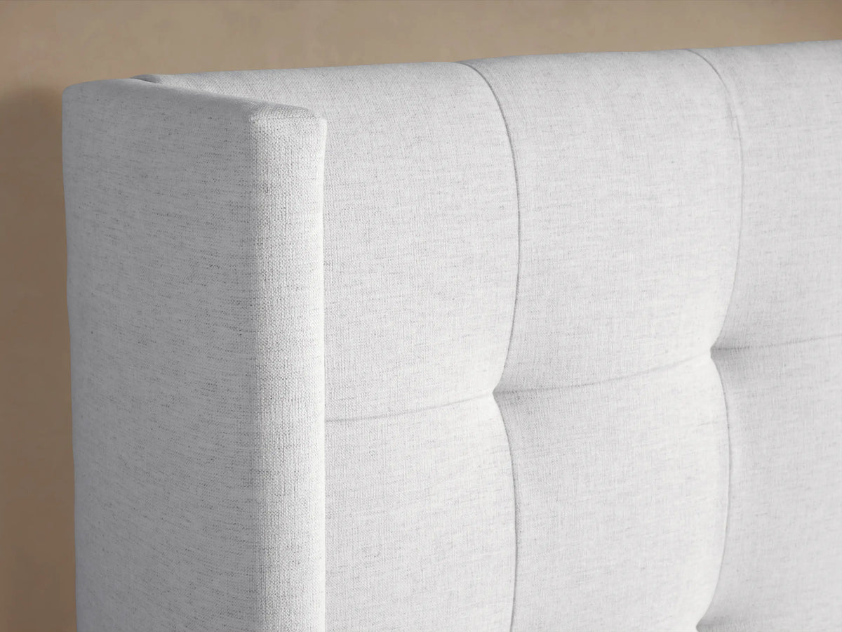 Wyller Box-Tufted Bed: light grey fabric, high box-tufted headboard, low footboard, with white pillows & duvet, centered.