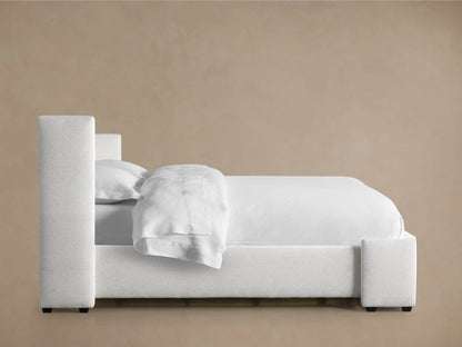 Close-up of Wyller Box-Tufted Bed's light gray woven fabric headboard, showing square tufting and a sturdy upholstered side panel.