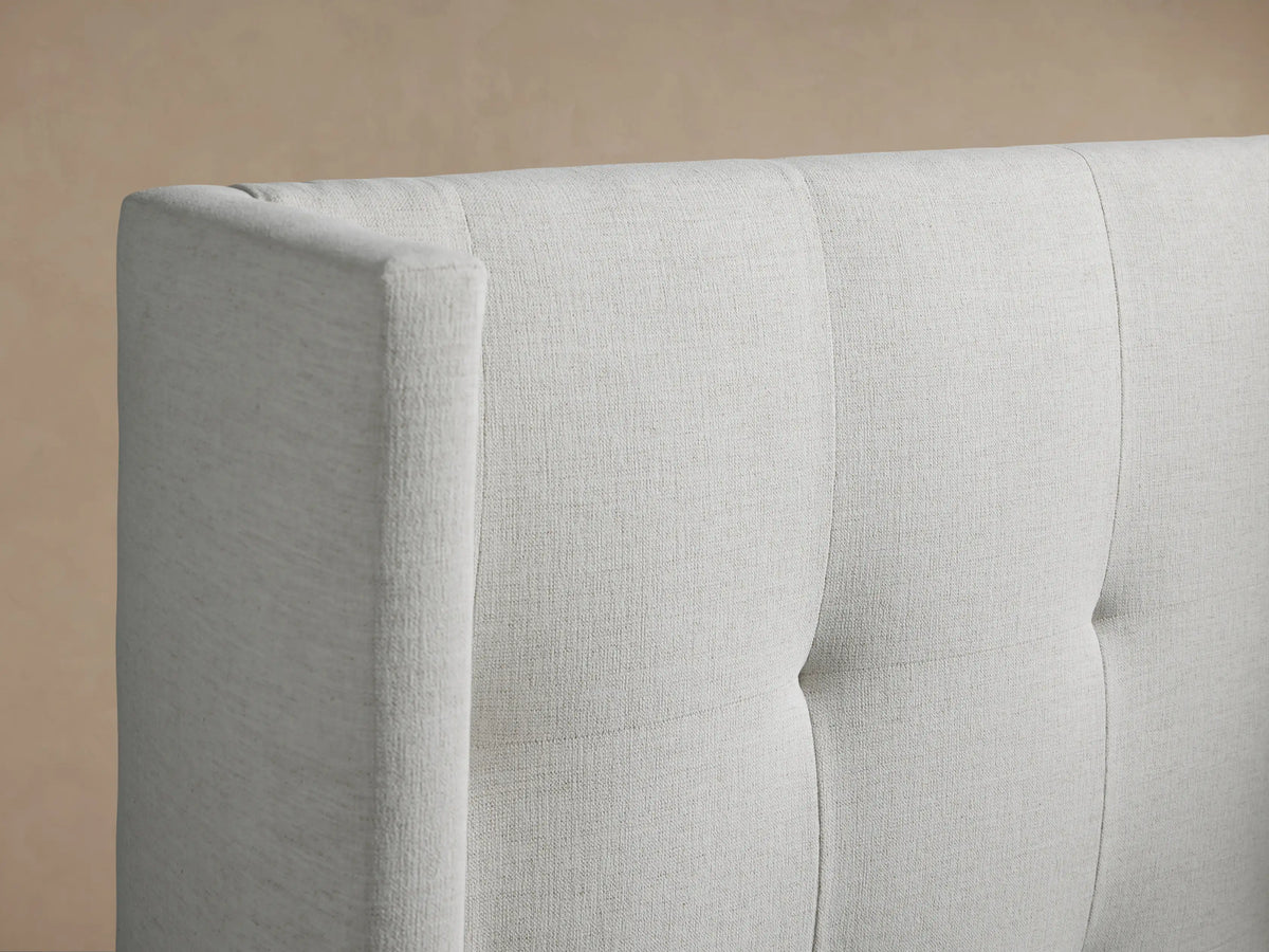 Front view of Wyller Box-Tufted Twin Bed, light grey upholstered, with tall, winged, box-tufted headboard & white bedding.