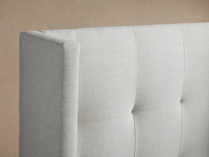 Front view of Wyller Box-Tufted Twin Bed, light grey upholstered, with tall, winged, box-tufted headboard & white bedding.