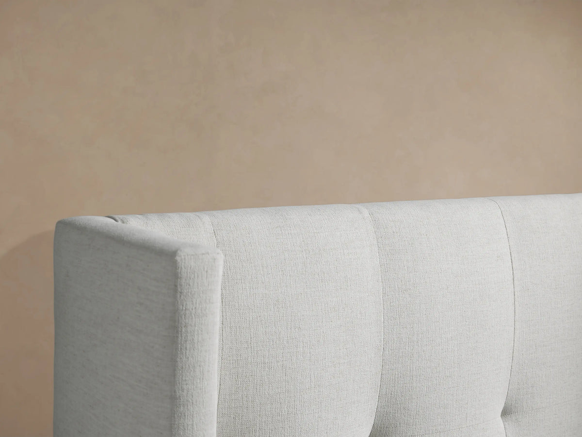 Wyller Box-Tufted Twin Bed, light gray upholstered, high wingback headboard with box tufting, white bedding, front view.