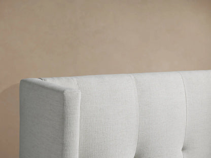 Wyller Box-Tufted Twin Bed, light gray upholstered, high wingback headboard with box tufting, white bedding, front view.