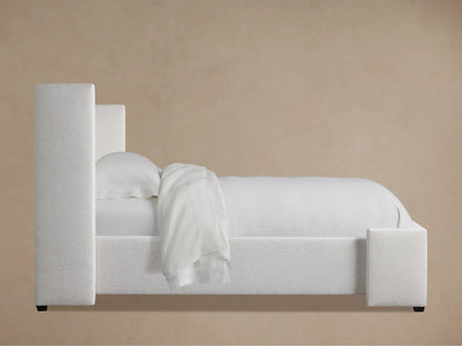 Close-up of Wyller Box-Tufted Twin Bed's light, textured fabric headboard with vertical tufting and padded side.