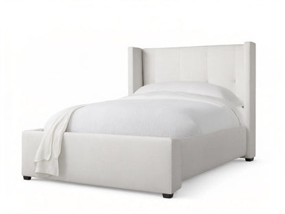 Light gray upholstered Wyller Box-Tufted Twin Bed with wingback, box-tufted headboard & white bedding on wood floor.