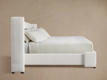 Wyller Channel-Stitched Extended Headboard close-up. Light neutral textured fabric, vertical channels & upholstered side.