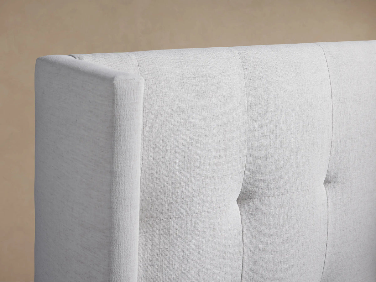 Front view of Wyller Box-Tufted Twin Bed, upholstered in light fabric, featuring a tall, winged box-tufted headboard.