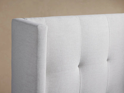 Front view of Wyller Box-Tufted Twin Bed, upholstered in light fabric, featuring a tall, winged box-tufted headboard.