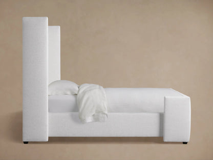 Close-up of a light gray upholstered Wyller Twin Bed headboard, showing textured fabric and box-tufted detailing.