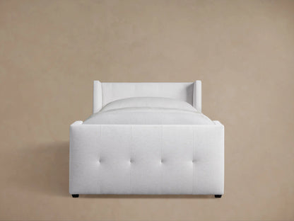 Angled view of a Wyller Box-Tufted Twin Bed, upholstered in white fabric, with tufted headboard and footboard.
