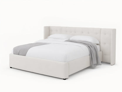 Wyller white box-tufted extended headboard bed with low footboard, in a room with tan walls and wood floor.