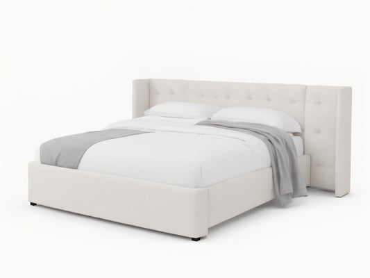 Wyller white box-tufted extended headboard bed with low footboard, in a room with tan walls and wood floor.