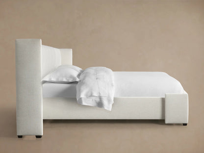 Close-up of Wyller extended headboard with box-tufting, upholstered in light beige textured fabric.