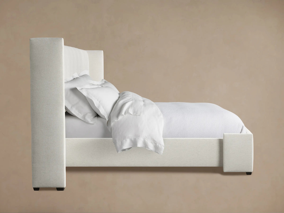 Wyller Box-Tufted Extended Headboard Bed in light neutral fabric, with an extended box-tufted headboard & low footboard.